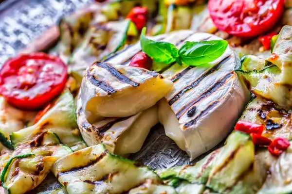 Grillowany ser camembert z cukinią, pomidorami i bazylią.