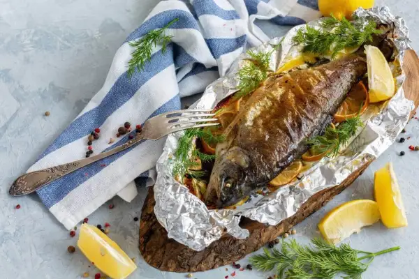 Pieczony pstrąg w folii aluminiowej z cytryną i koperkiem.