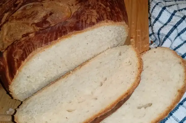 Pokrojony bochenek domowego chleba z chrupiącą skórką i miękkim wnętrzem.